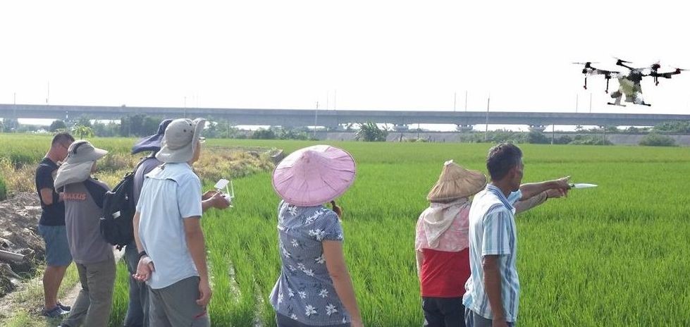 與臺南試驗區附近的農民介紹無人機施藥的便利性