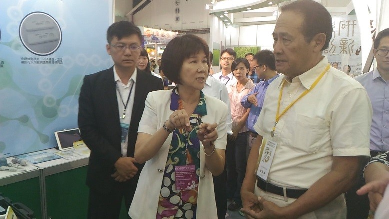 農委會曹主委啟鴻(右)參觀本所成果展示區，費雯綺所長說明導覽