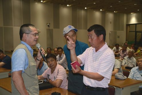謝再添助理研究員(左)回答農友疑難問題。